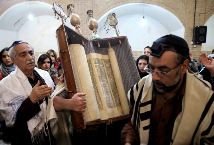 Un judío iraní sostiene un rollo de la Torá en la sinagoga Molla Agha Baba, en la ciudad de Yazd · Crédito Ebrahim Noroozi/AP