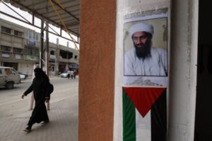Foto del fundador de Al Qaeda y ex líder Osama Bin Laden por encima de una bandera de la Autoridad Palestina. Crédito de la imagen: Abed Rahim Khatib / Flash 90